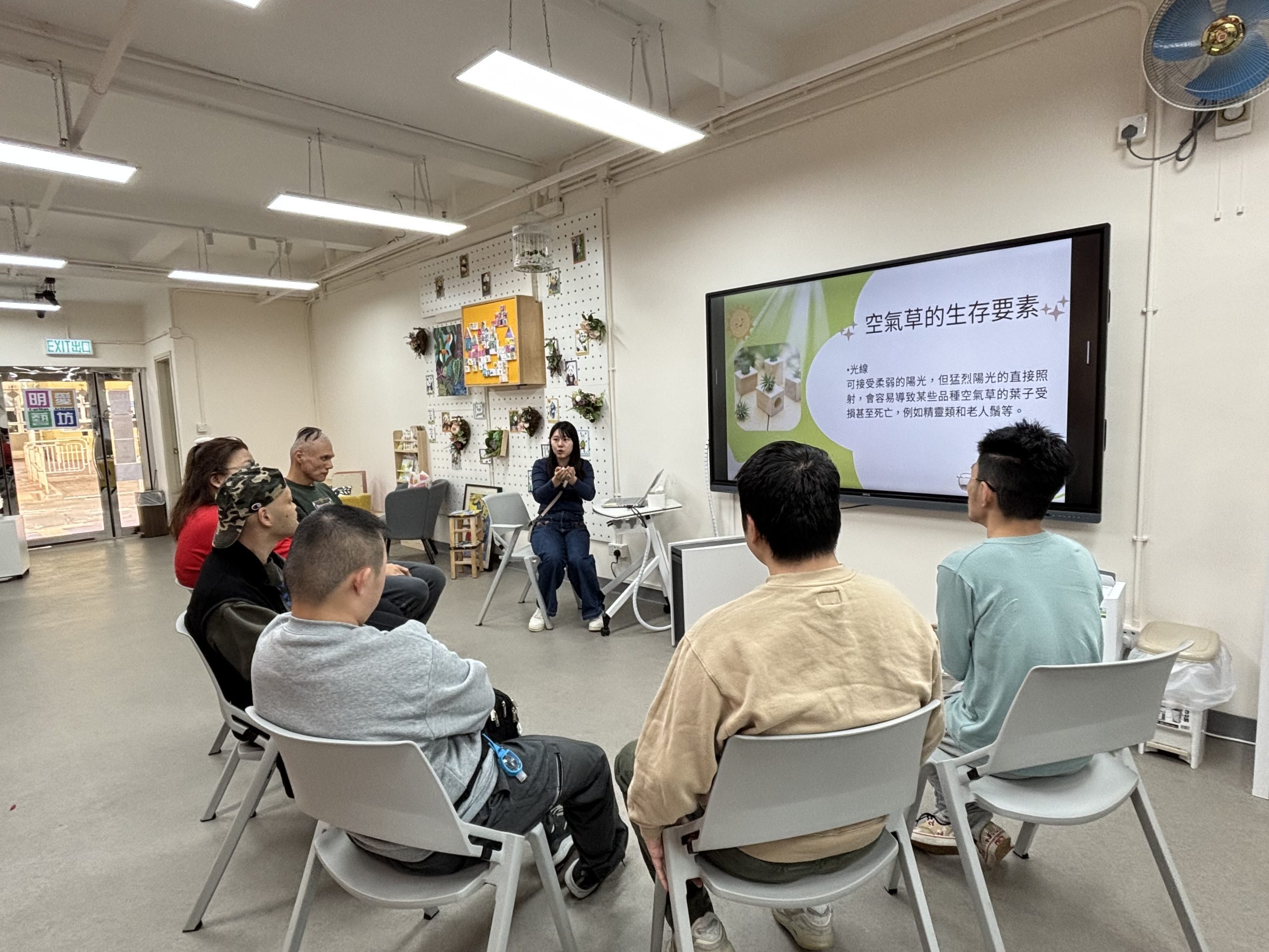Team members are sitting in chairs, gathered in a room, focusing on group activities.