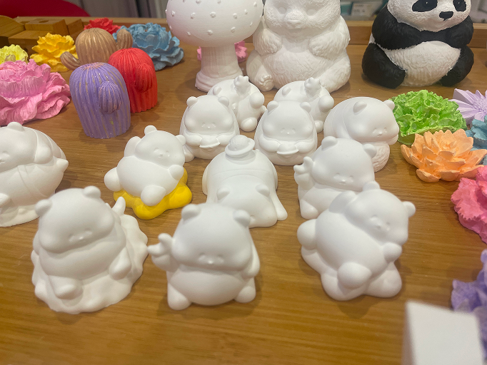 一张桌子上摆放着许多不同形态的白色熊猫扩香石,展现出简约而优雅的艺术风格。