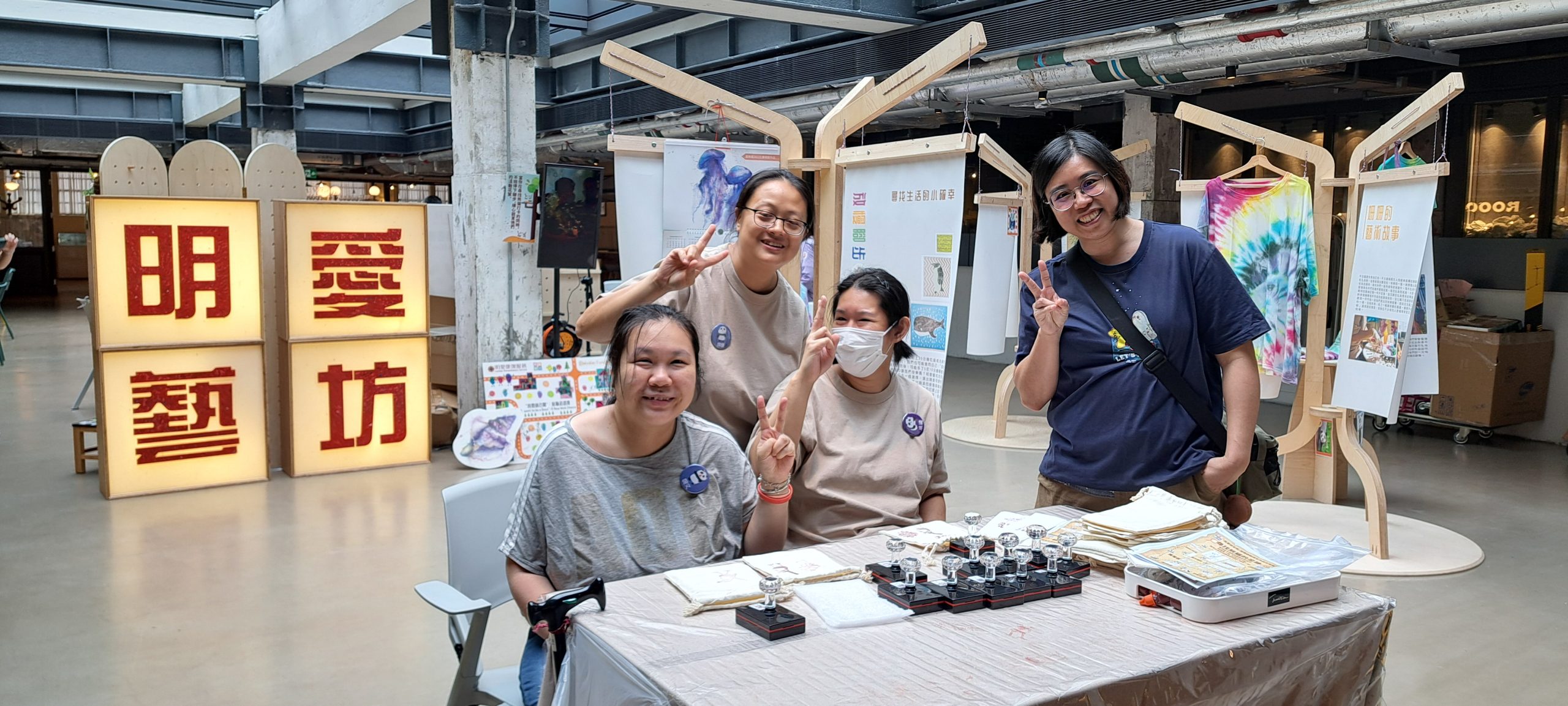 三位會員與義工坐在桌子旁為製作手工布袋作準備。