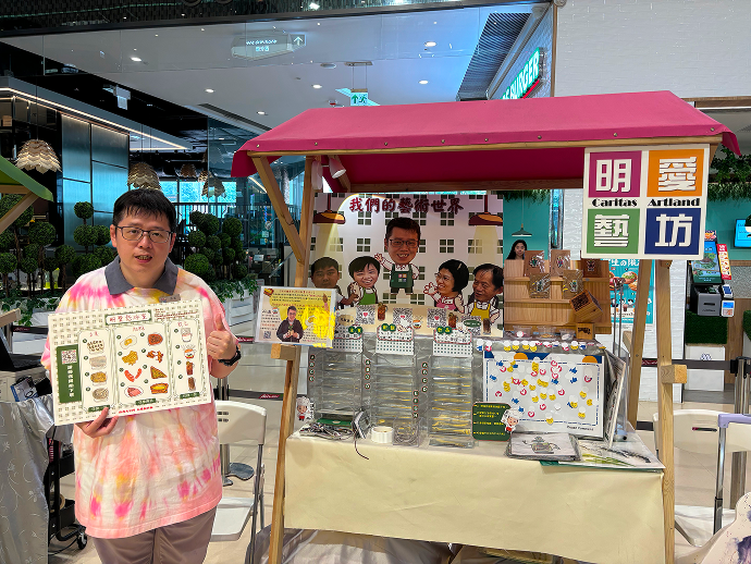 老闆阿滿與明愛樂群學校郭校長手持明愛您冰室餐牌在攤位前拍照留念。