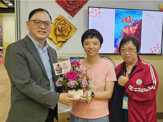 高級督導主任黎先生及督導主任林姑娘代表中心致送花籃予老闆Mini。