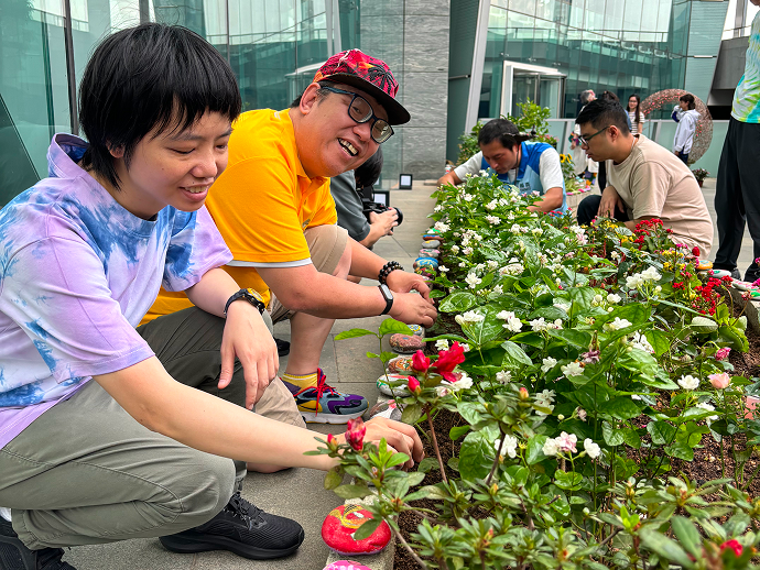 三位會員面帶笑容正努力裝飾花園。