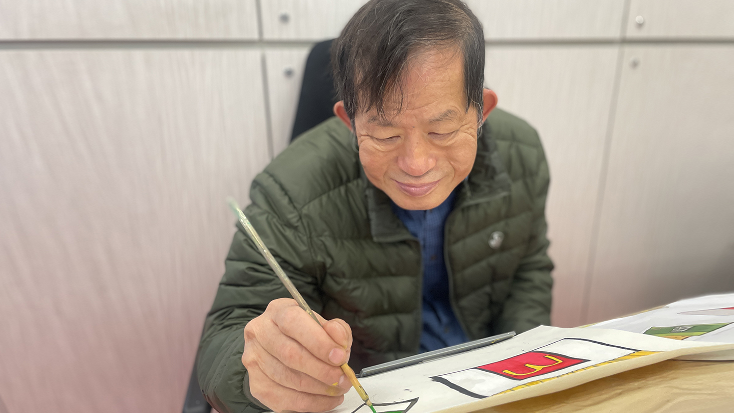 Boss Man is concentrating on his drawing on paper, showcasing his artistic talent and creativity.